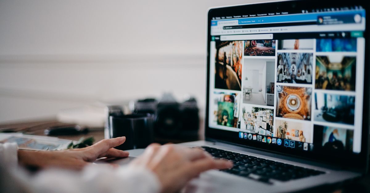 Persoon werkt op een laptop met een raster van diverse afbeeldingen op het scherm in een rustige kantooromgeving