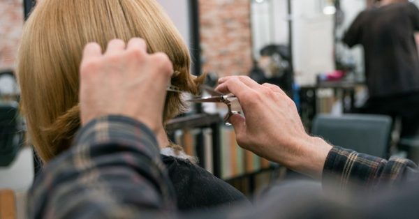 Hairdresser cutting the blonde hair of a client in a professional salon setting