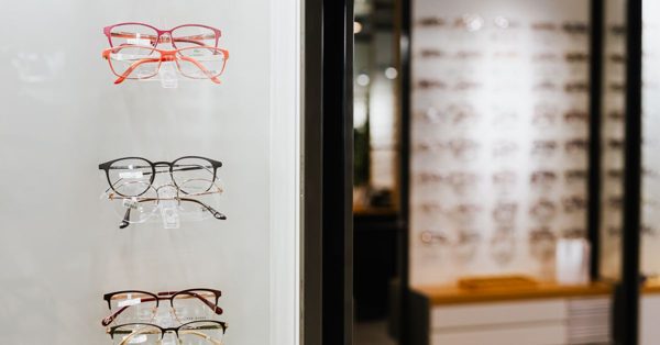 Verschillende brillen op een verlichte display in een moderne opticienwinkel met een wazige achtergrond van monturen